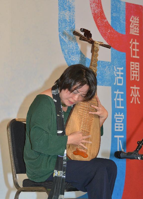 The Music Director of Wuji Ensemble, Wong Chi-ching, gives a pipa performance during the press briefing.