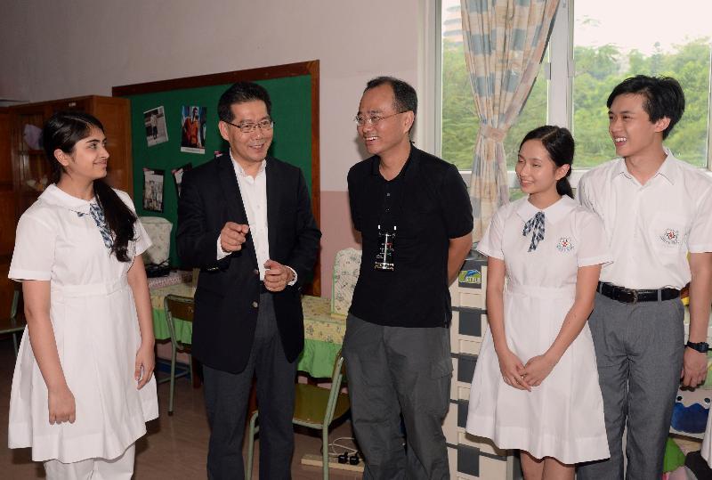 Mr So (second left) exchanges views with Mr Cheung (centre) and young actors who are participating in the filming of a feature film for the first time on their experience in the film project.