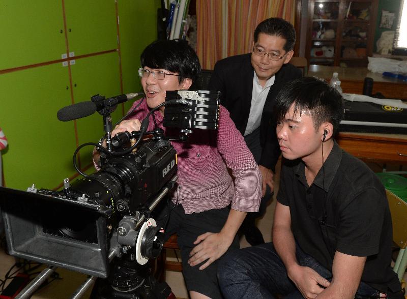 Mr So (centre) listens to the production crew's introduction of the filming process.