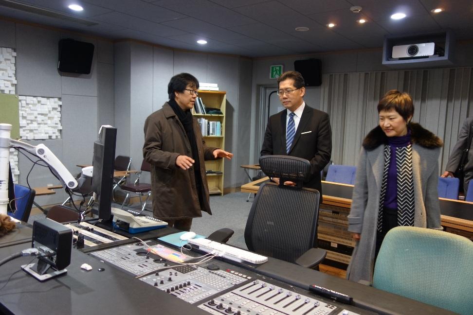 Mr So (centre) is briefed on the university's audio recording facilities.